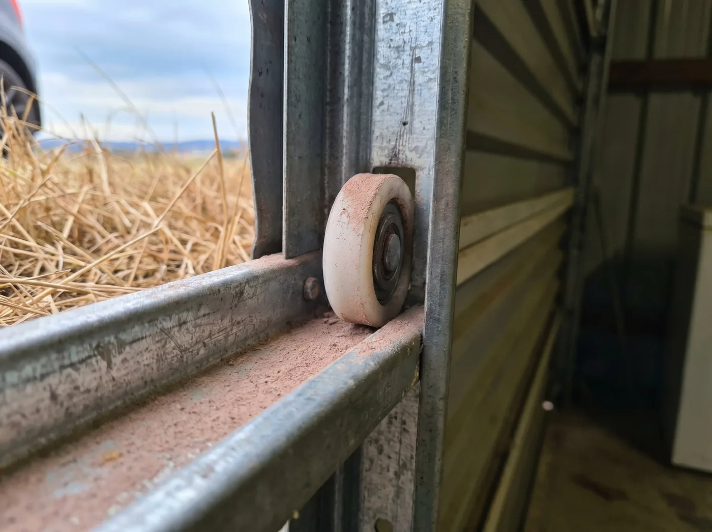Fine valley dust settled on a garage door track and roller
