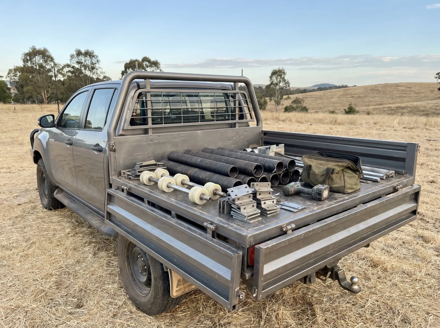 A ute tray carrying garage door springs, rollers, brackets and tools